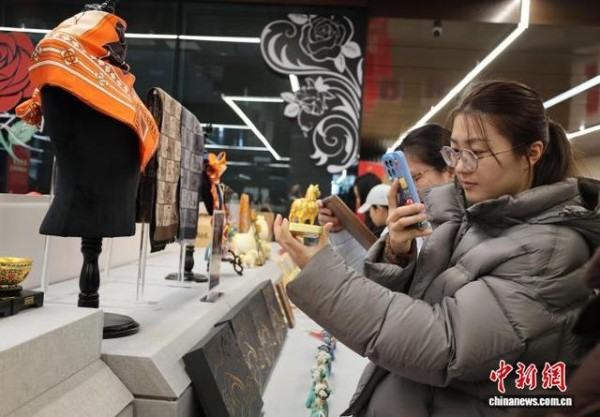2月10日，游客在孔子博物馆文创展销区选购黄玉马文创。中新社记者 赵晓 摄