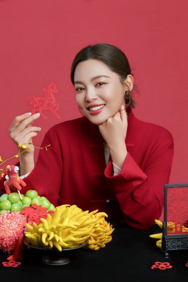 辛芷蕾手持马年剪纸，手托脸颊。