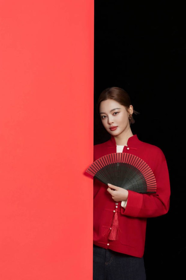 辛芷蕾持红黑折扇，眼神慵懒。