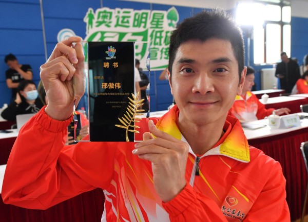 体操运动员邢傲伟展示“奥运明星绿色低碳宣传队”聘书。新京报记者 王贵彬 摄