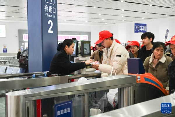 2月22日，来自黔东南州各区县的外出务工人员及家属在凯里南站检票进站。新华社发（邵健摄）