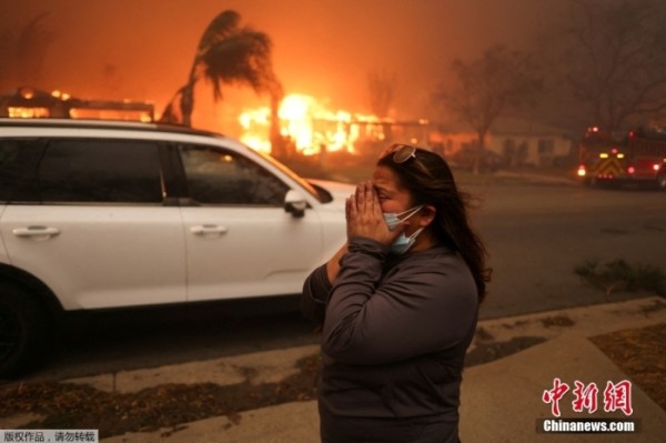 据美联社报道，当地时间1月8日，大规模山火席卷美国洛杉矶地区，已致至少5人死亡，大量人员受伤。另据路透社报道，已有超过10万人被迫撤离。图为当地时间1月8日，美国加州洛杉矶县阿尔塔迪纳，一名妇女撤离受灾地区。
