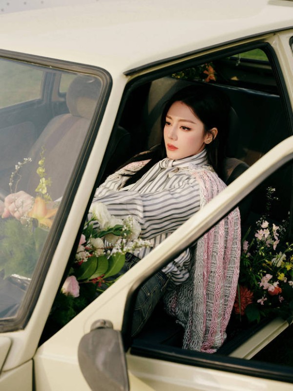迪丽热巴车内满是鲜花,眼神沉静,松弛文艺。