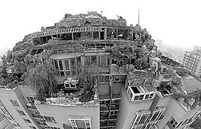 15日，张必清在人济山庄房顶的假山和违建开始拆除