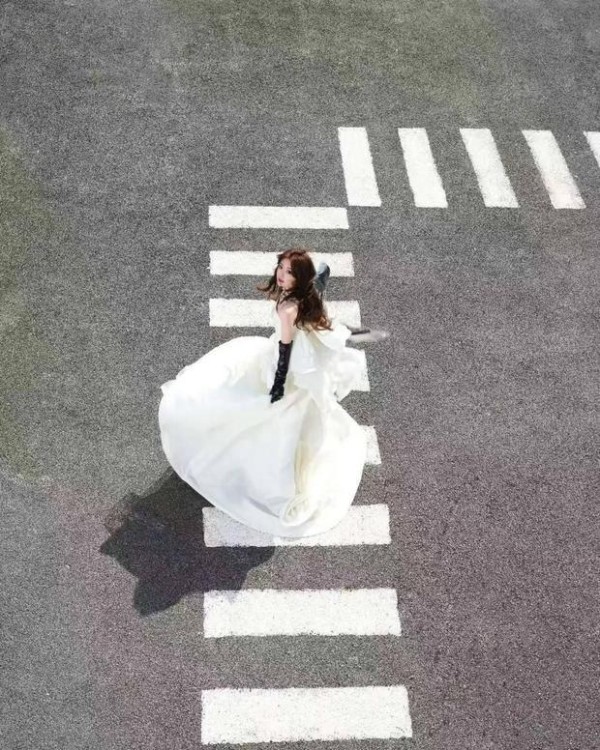 毛晓彤白纱裙搭配皮质手套 发丝飞扬明媚动人