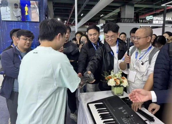 佩戴强脑智能假肢的工作人员与探展团成员握手