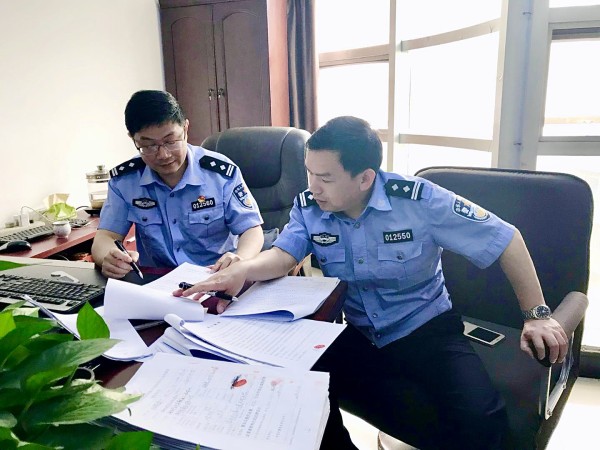 魏和友（右）生前和同事在讨论工作。南昌市公安局东湖分局供图