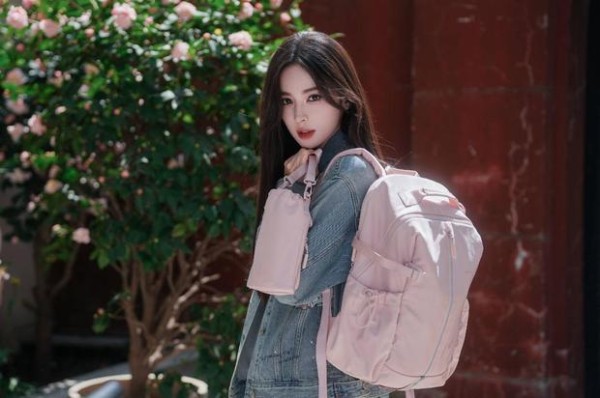 搜狐娱乐讯 近日，古力娜扎一组街拍曝光。她穿卡通印花牛仔套装，背粉色双肩包，花前摆拍，尽显青春活力。