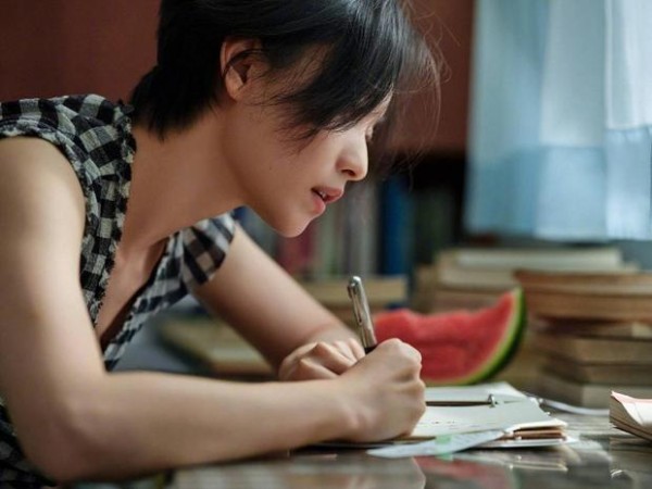 倪妮伏案书写,神态温柔治愈。