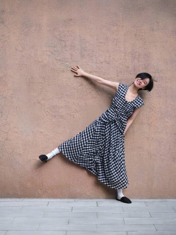 倪妮靠墙摆拍,格纹裙活力满满。