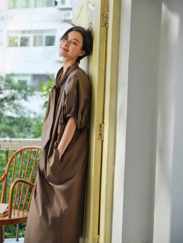 倪妮倚门,咖色长裙松弛感拉满。