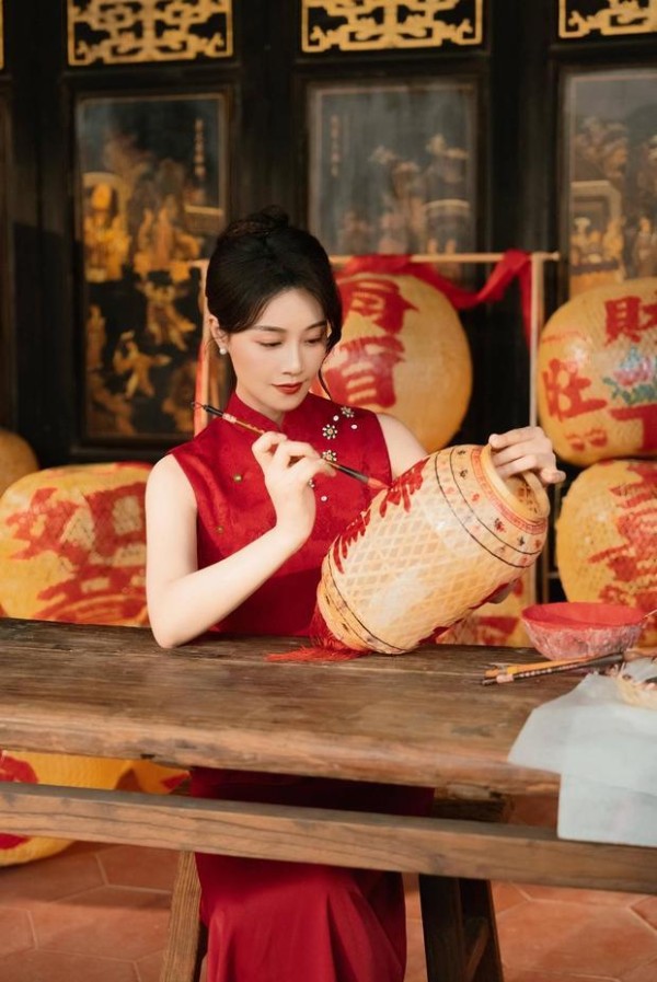 蓝盈莹神情专注，认真地在灯笼上写字。