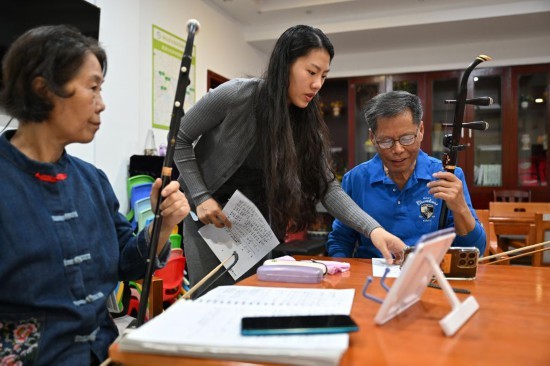 在海口市琼山区文坛社区养老服务站，老年人在学习拉二胡。新华社记者 郭程 摄