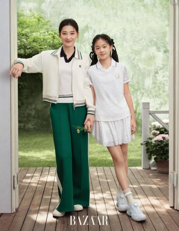 梅婷与女儿快快牵手笑容明媚，活力又温馨。