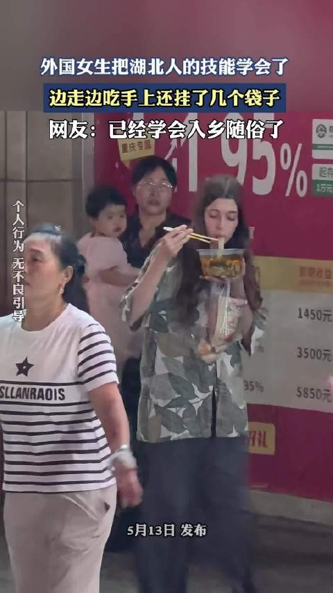 外国女生把湖北人的技能学会了，边走边吃手上还挂了几个袋子！