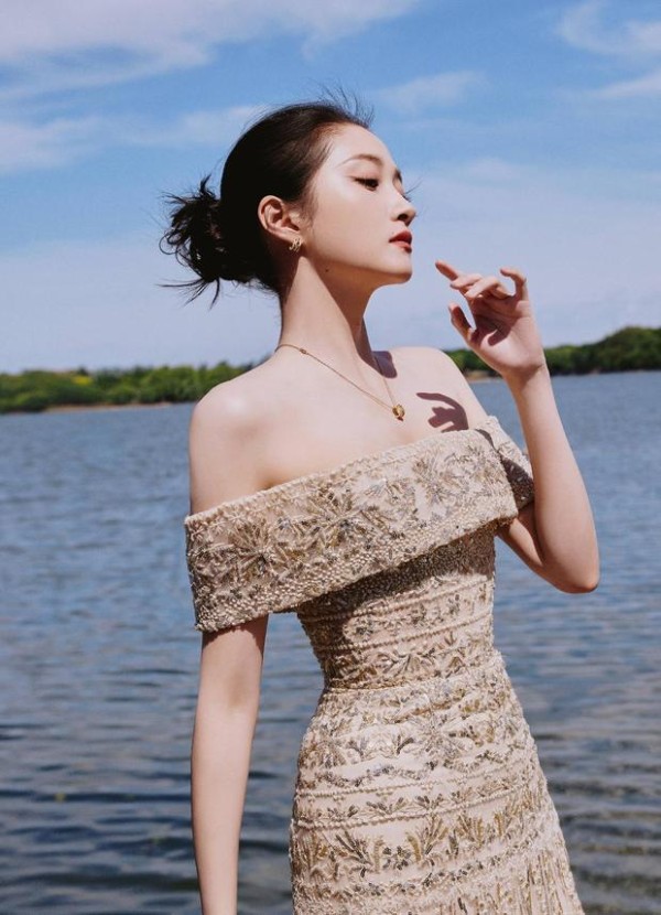 关晓彤侧身抬眸,水光与亮片裙呼应。
