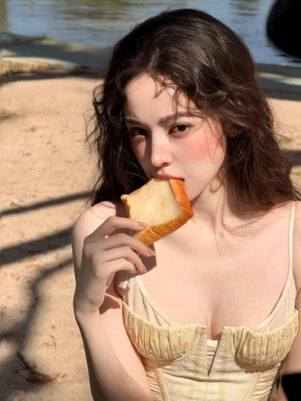 娜扎一边吃面包一边俏皮看着镜头。