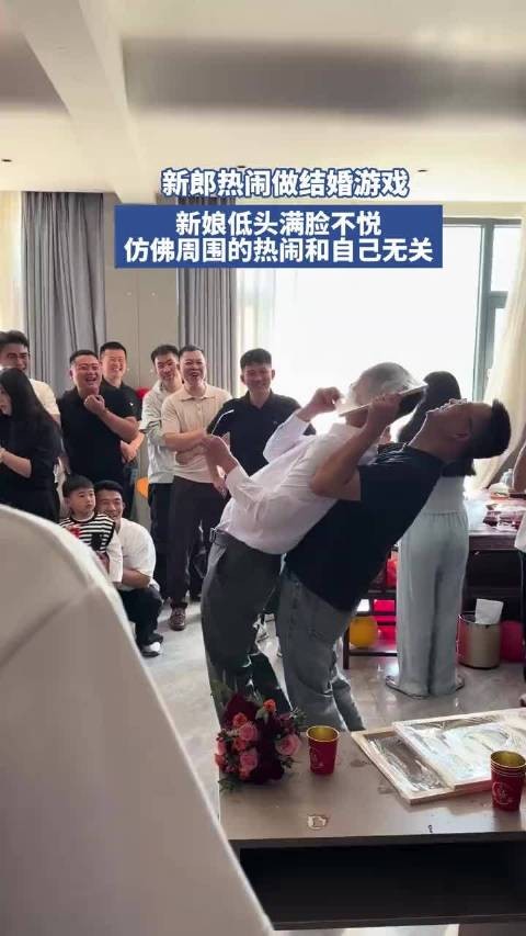 新郎热闹做结婚游戏,新娘低头玩手机仿佛周围的热闹和自己无关!