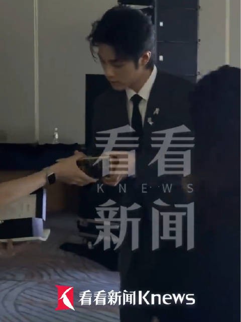 肖战捧着奖杯躬身递给同伴
