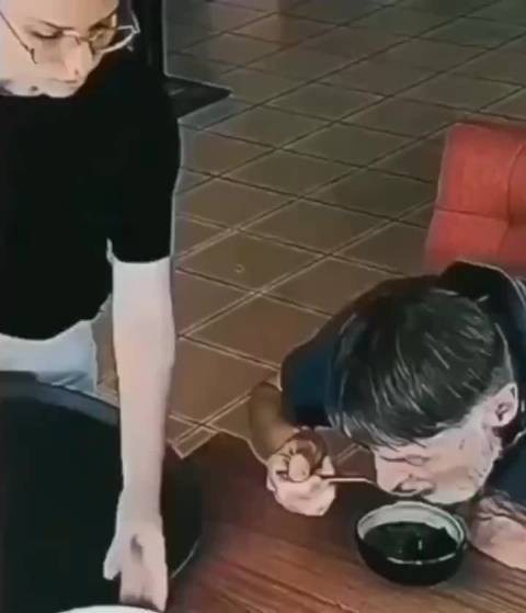 一个无家可归的家伙在吃剩饭,女服务员把剩饭拿走,给他端上了新鲜的食物